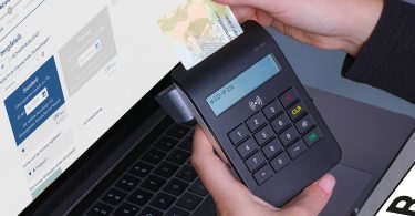 a person useing swipe card machine for payment